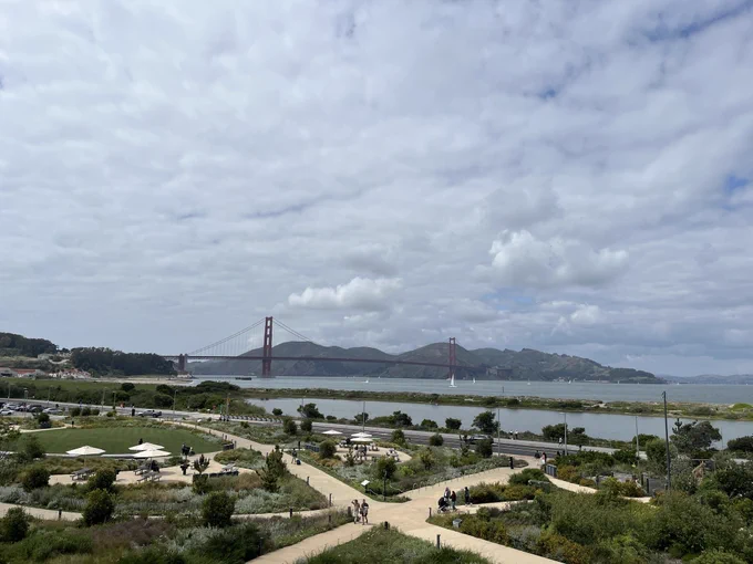 View of Golden Gate Bridge with Presidio tunnel tops park in front on a sunny and cloudy day