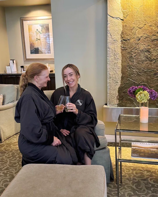A photo of a mom and daughter in robes at Salamander Spa at Innisbrook Resort, relaxing in the lounge with champagne.