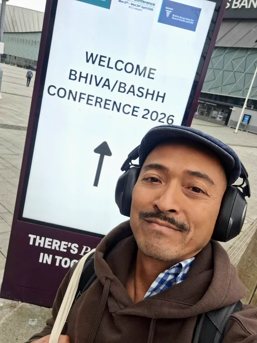 Selfie of me in front of BASHH BHIVA conference poster