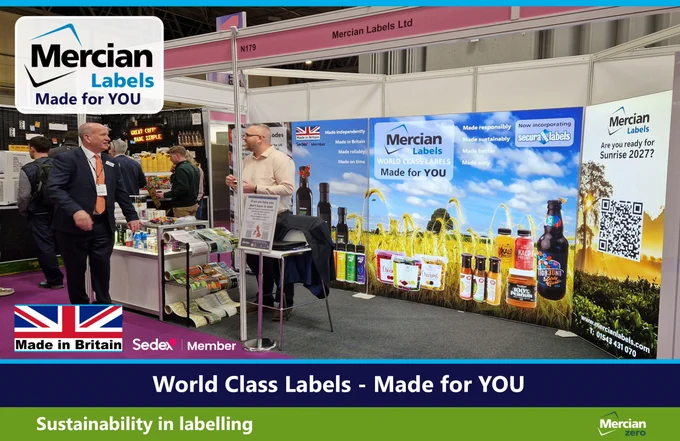 Exhibition stand for Mercian Labels featuring large, brightly lit, branded displays with the slogan “World Class Labels - Made for YOU.” The stand showcases sample product labels on bottles, jars and packaging, with messaging about sustainability and British manufacturing. Two men in business attire stand and converse beside a display table of printed labels. The image includes a Made in Britain logo, Sedex Member logo and a QR code panel asking “Are you ready for Sunrise 2027?”
