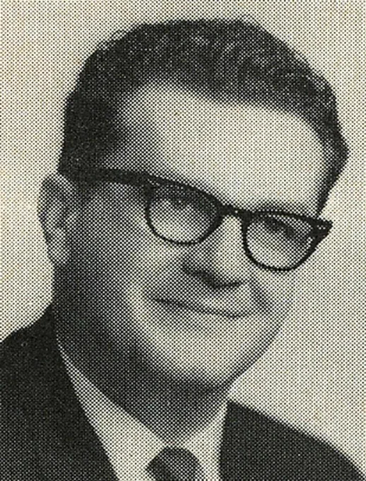 Black-and-white portrait of a white man in glasses and a suit. The image has a vintage halftone texture.