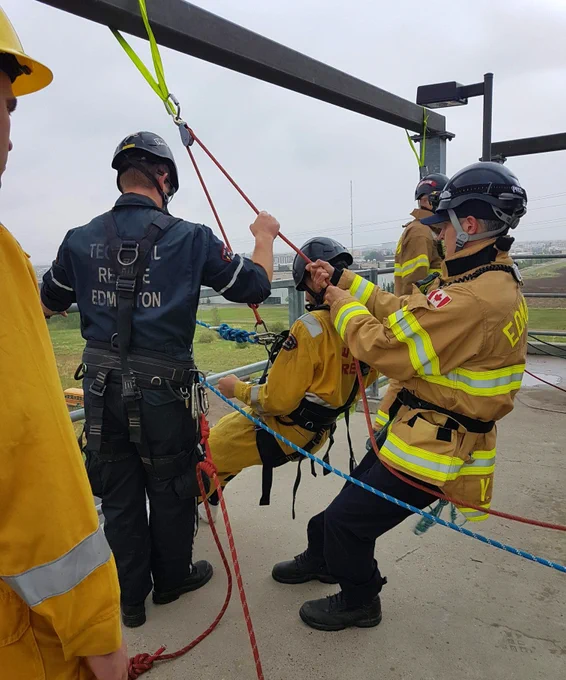 Young cadets getting ready to rappel off a roof.