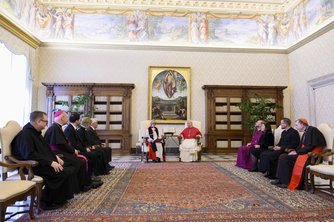 Pope Leo XIV and Archbishop Sarah sit at the end of a room in separate highbacked chairs. Four members of the delegation sit in a row at either side of Pope Leo XIV and Archbishop Sarah.