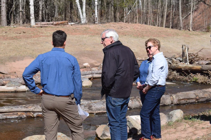 Gov. Evers looks at creek while on tour of restoration site