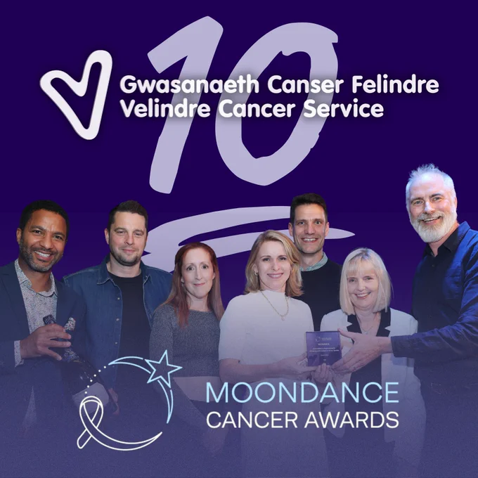 A group of people receiving an award and smiling.