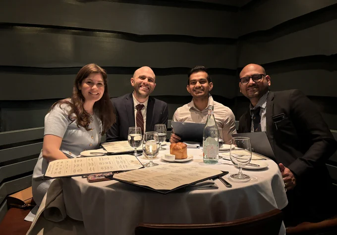 Group photo of Drs. Moore, Warning, Vadhul, Varma around a table at a restaurant in Boston