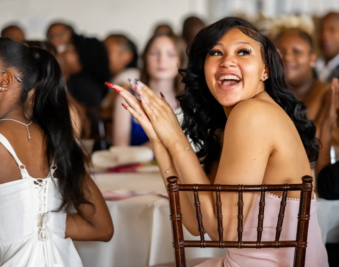 A student smiles and claps.
