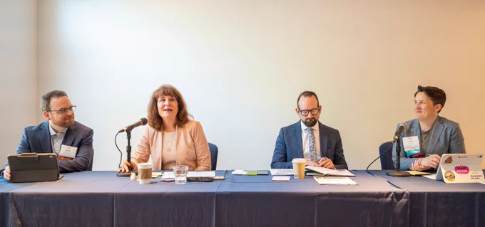 Two men and two women sit at a table.

