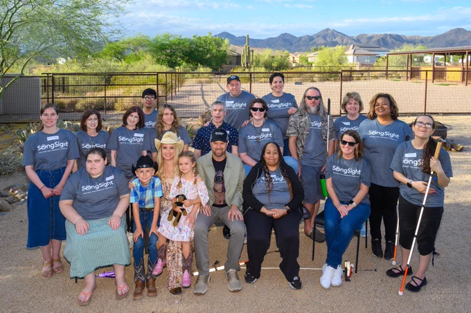 Whole group of attendees posed outdoors wearing t-shirts with SongSight visible