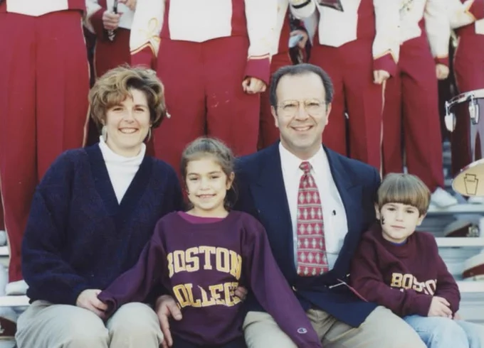 An old photo of Seb Bonaiuto and his family sitting on stadium stands, with the BC Marching Band behind them.