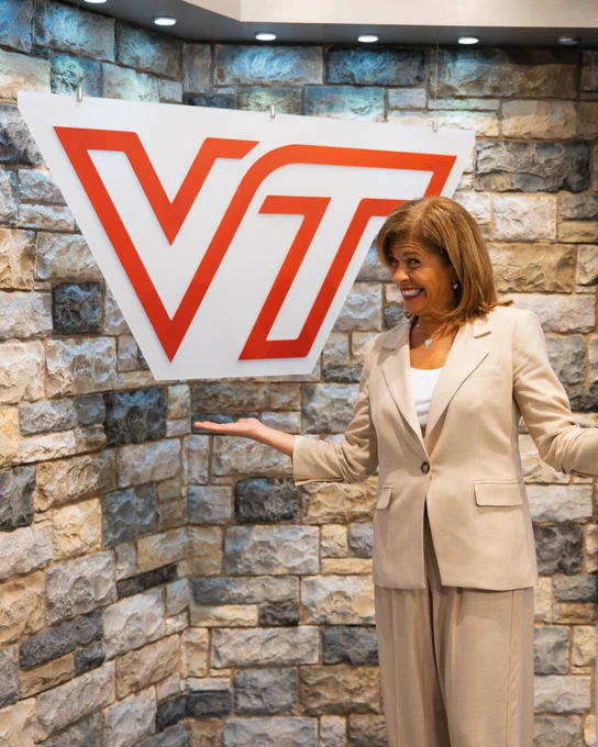 Hoda Kotb smiles in front of a Virginia Tech sign and Hokie Stone.