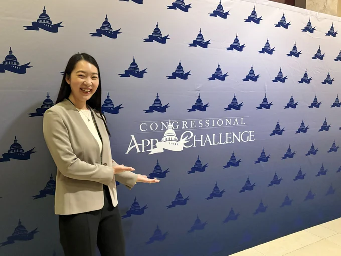 Natalie Lao standing in front of the Congressional App Challenge backdrop.