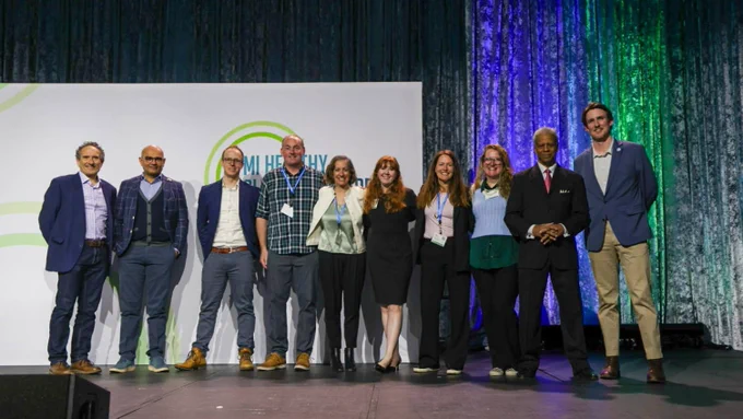 Awardees for MI Healthy Climate Challenge #3: Growing Green Lending stand together on stage at the MI Healthy Climate Conference.