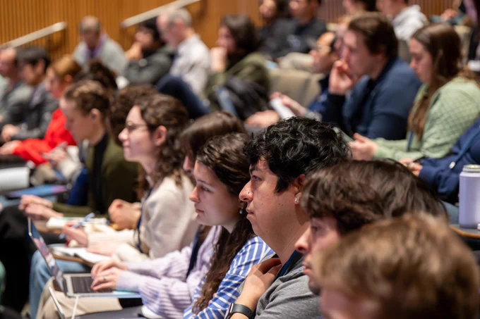 Students seated in rows of seats in an auditorium observing a lecture
