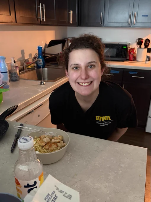 Liv smiles next to a bowl of ramen.