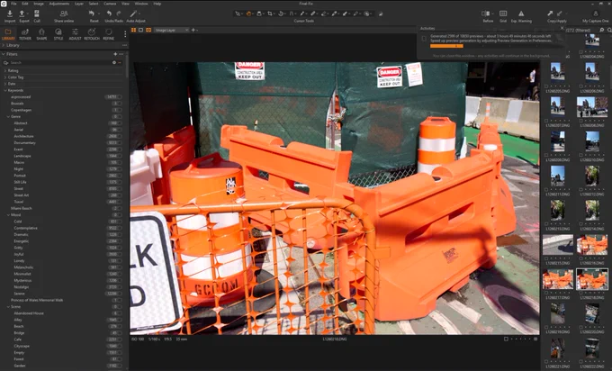 Screenshot of Capture One on Windows showing AI-generated keyword hierarchy in the left panel. Visible categories include Genre with values like Documentary, Street, Travel, and Architecture; Mood with Contemplative, Serene, and Joyful; and Scene with Cafe, Cityscape, and Alley. The main view shows a street photograph of bright orange construction barriers and traffic cones in front of a green construction fence with Danger Keep Out signs.