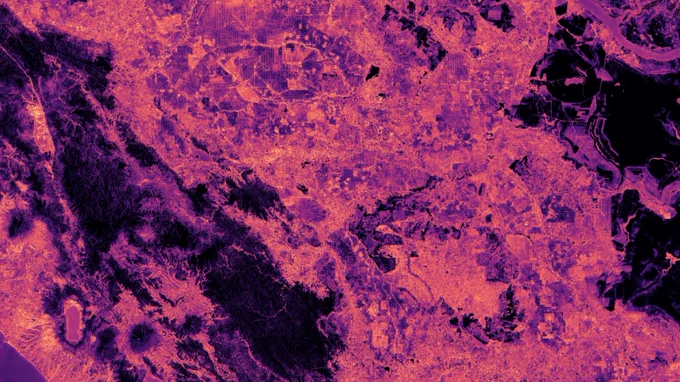 A false-color satellite view of a vast landscape is depicted in shades of magenta, pink, and deep purple.