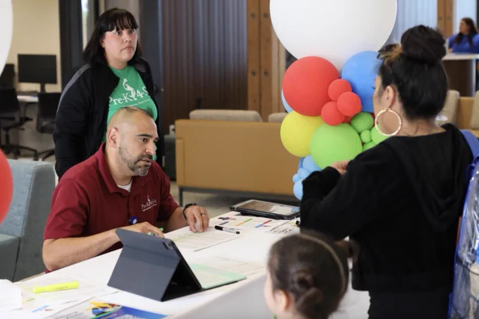 A Pre-K 4 SA team member talking to a family at Welcome to Kinder. 