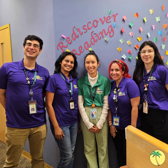 Hagen Ranch Road staff in purple library shirts, in front of their "Rediscover Reading" sign.