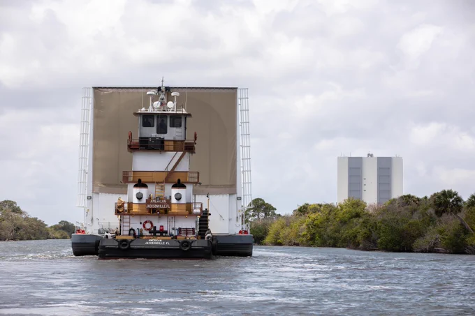 NASA's Pegasus barge on the water near the Kennedy Space Center's Vehicle Assembly Building