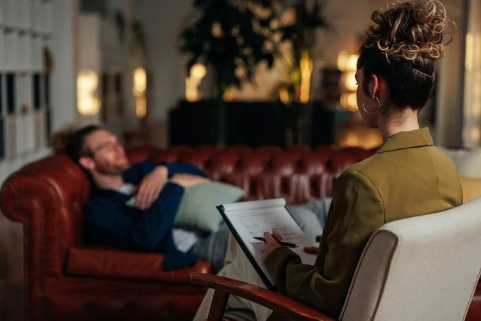 A therapist counsels her patient in a cozy office space