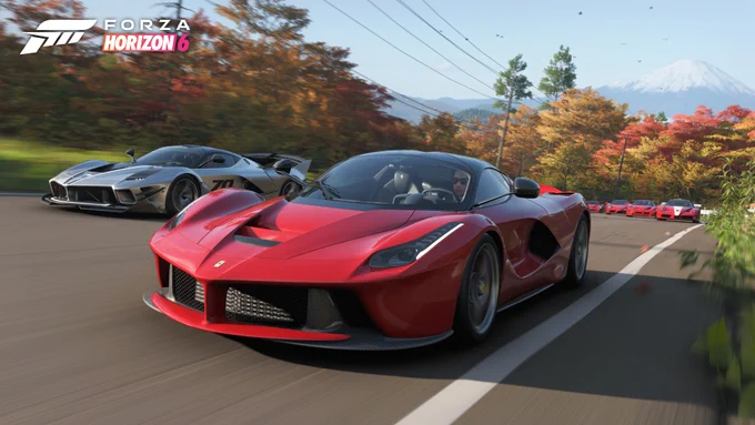 A red Ferrari sports car leads on a scenic road, followed closely by a silver sports car. The background features fall foliage and a distant mountain. The logo for "Forza Horizon 6" is displayed at the top.