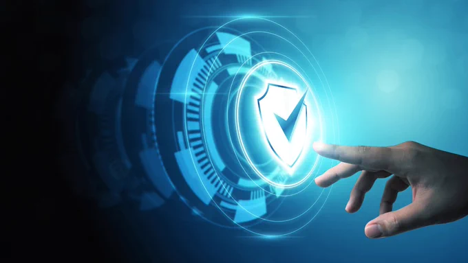 Hand reaching towards a glowing shield icon with a checkmark, symbolizing digital security and protection.