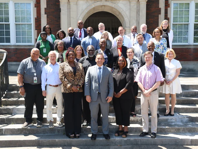 Superintendent Dr. Mike Daria, center, stands with Cognia officials, TCS Board of Education members, TCS Executive Staff and TCS principals.