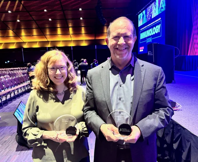 Sarah Gaffen and Dario Vignali holding their American Association of Immunologists (AAI) Distinguished Fellow of 2026 awards at the AAI meeting in Boston.
