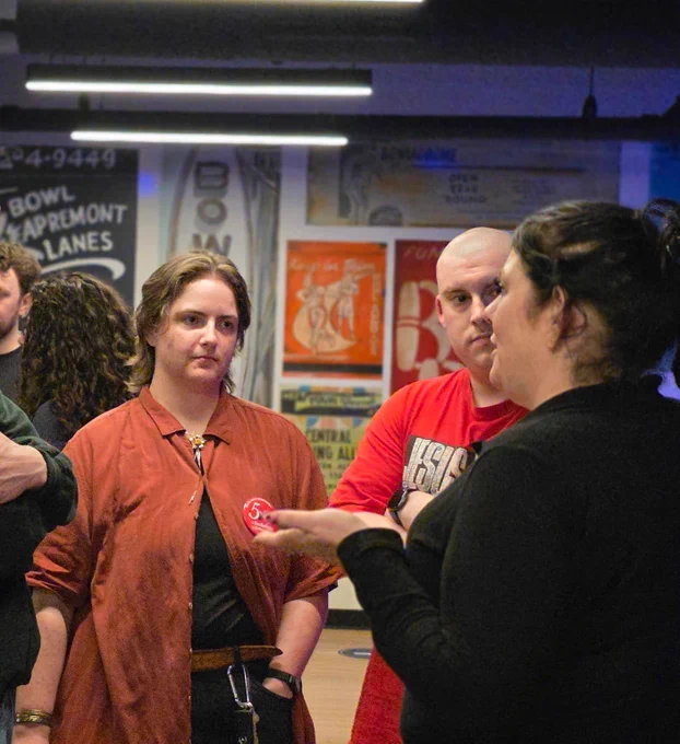 Members talk with a worker at the bowling alley