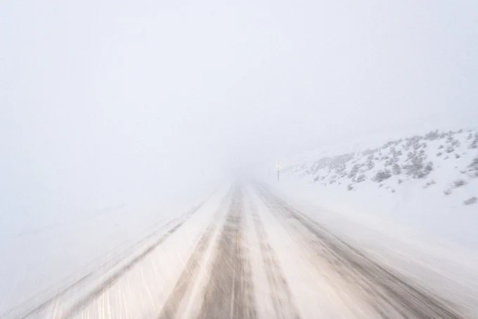 Driving through a blizzard on a snow-covered road