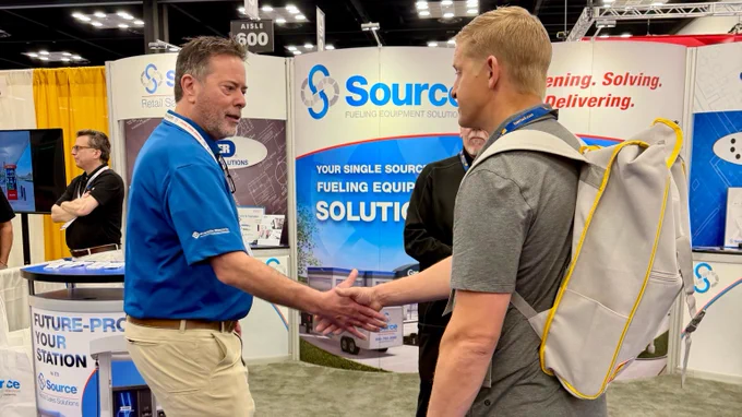 Photo of people visiting the Source booth, 826, during the M-PACT Fuel & Convenience Tradeshow.