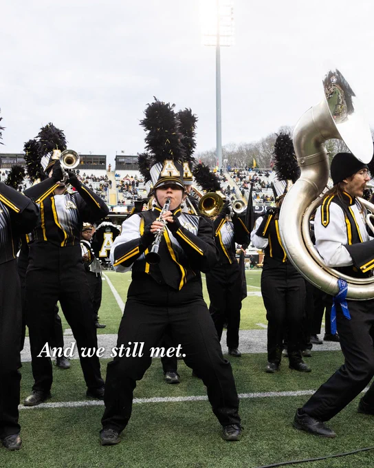 Members of the Marching Mountaineers performing on the field during a football game at Kidd Brewer Stadium.