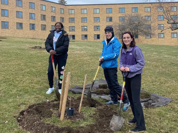 Students and volunteers plant and care for trees during an Arbor Day event as part of SUNY Oswego’s Earth Month celebration.