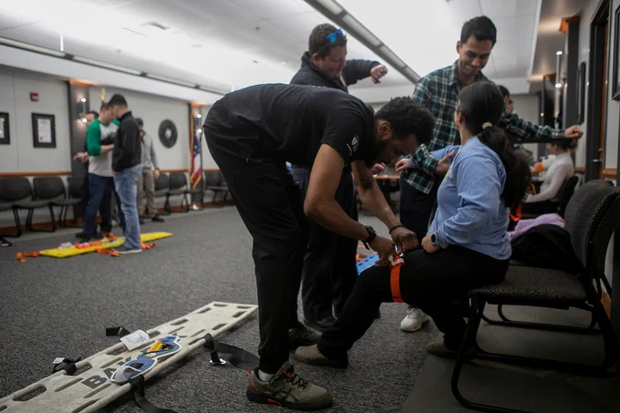 Medical students practice emergency medical techniques and patient stabilization during a training workshop.