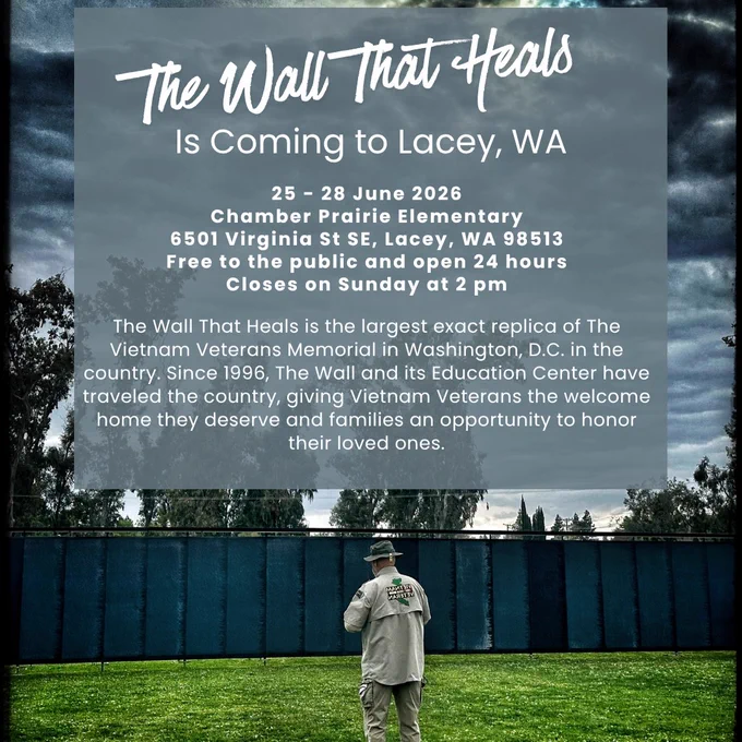 Alt-text: Social media flyer announcing “The Wall That Heals” coming to Lacey, Washington. Text reads: “25–28 June 2026, Chamber Prairie Elementary, 6501 Virginia St SE, Lacey, WA 98513. Free to the public and open 24 hours. Closes on Sunday at 2 pm.” Background shows a cloudy sky above a long dark memorial wall, with a person standing on grass facing the wall.