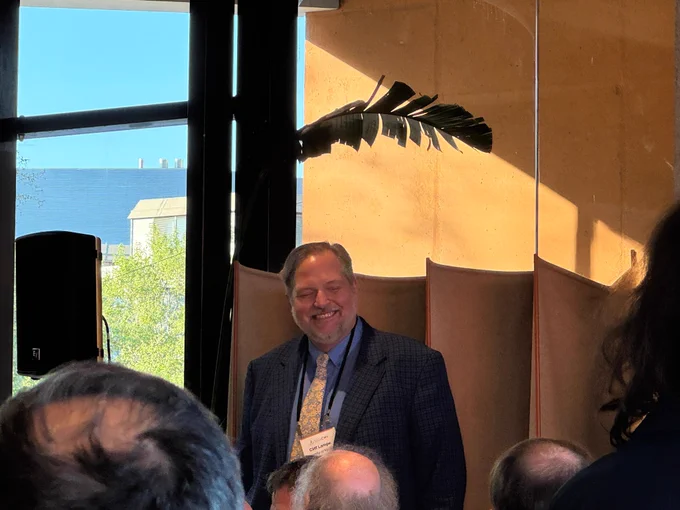 Lampe smiling. He is wearing a suit & wearing his CHI 2026 badge.