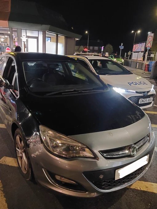 Vauxhall Astra in front of a marked police vehicle awaiting seizure for no insurance