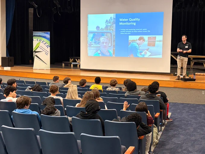 A man presenting to an auditorium of students