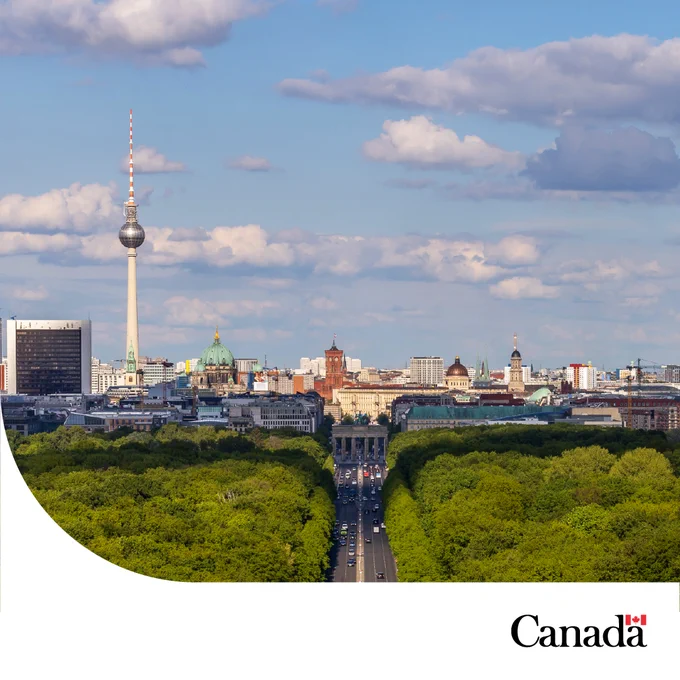 Berlin skyline with Brandenburg Gate and Television Tower, with the Tiergarten forest in the foreground. The Government of Canada logo is in the bottom right corner.