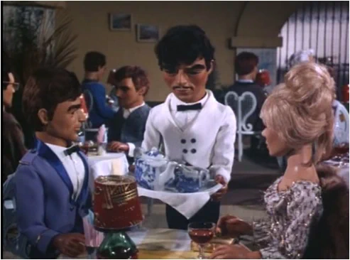 A couple at a French restaurant with a waiter. Everyone is a puppet.