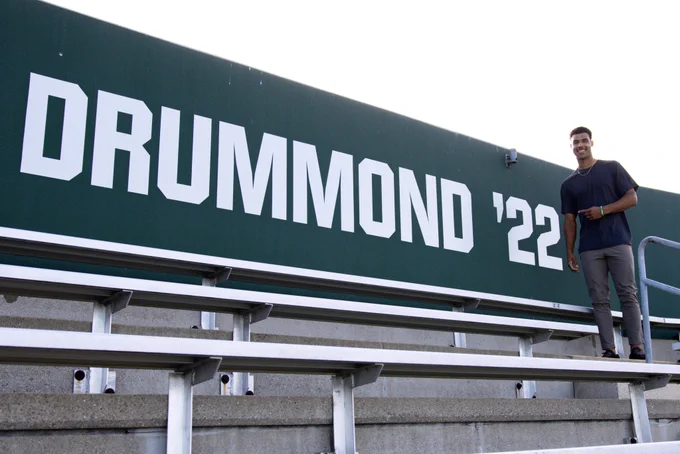 Dylan Drummond stands next to his Ring of Honor sign in Rynearson Stadium