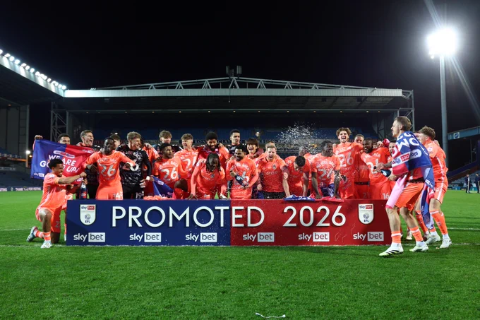 Coventry City players celebrate in front of the promoted 2026 banner.