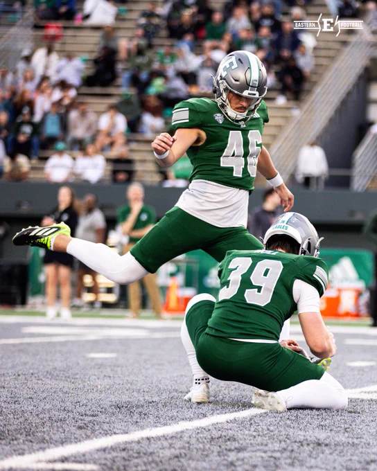 Daniel Hull holds the ball as Rudy Kessinger kicks the extra point