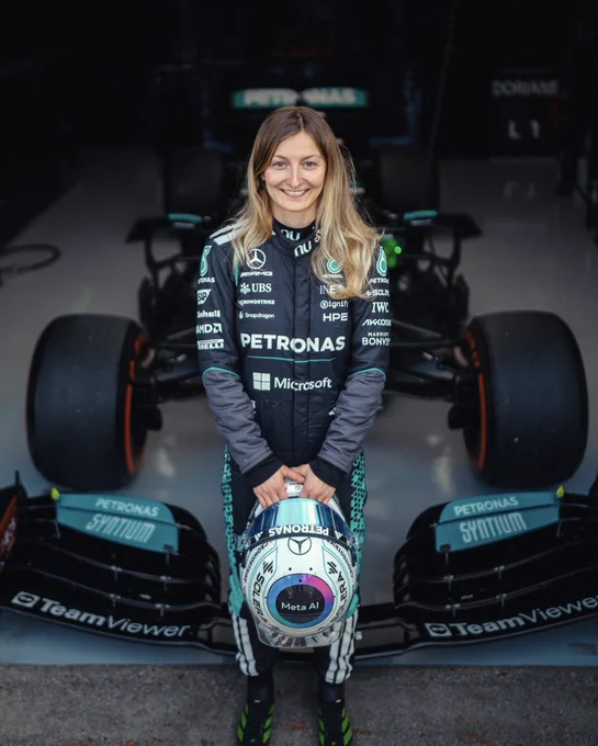 Doriane Pin in her Mercedes F1 race suit standing in front of the Mercedes W12 at Silverstone