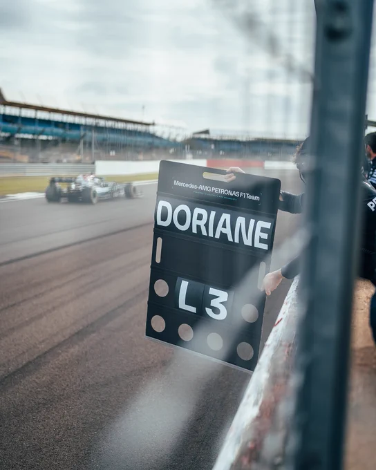 Doriane Pin driving W12 at Silverstone past her pit board saying her name and L3