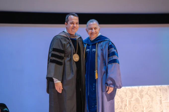 Dr. Bleris (Right in black regalia) standing next to Dr. Poras Balsara (Right in blue Regalia) after recieving award