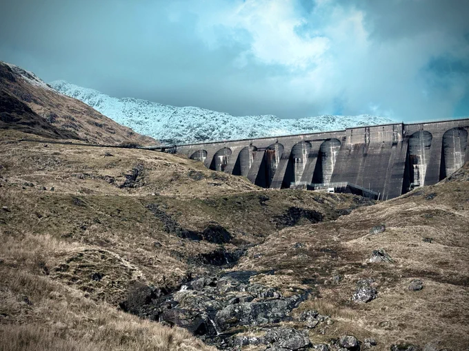 Cruachan Dam before a snow-covered mountaintop.