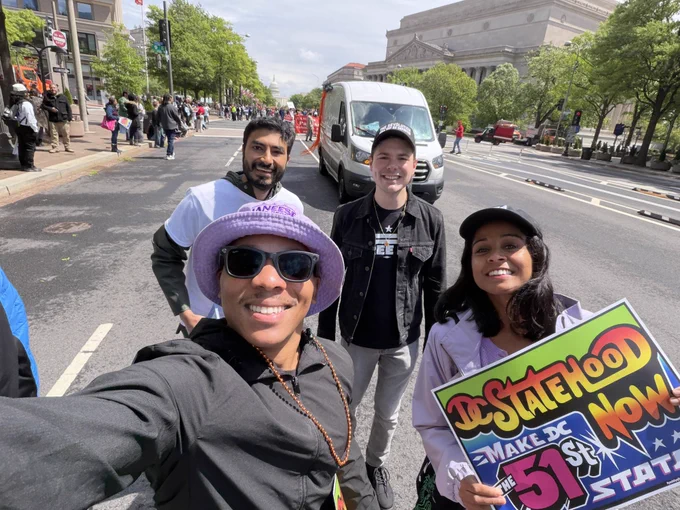 Selfie of Aparna, Howard, Ankit, and Steven walking with a DC Statehood sign