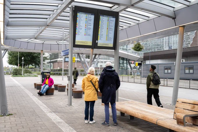 Reizigers bekijken informatie op schermen. Fotograaf: Robert Oosterbroek